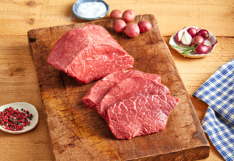 Portioned Boneless Bottom Round Roast steak on cutting board ready to cook.