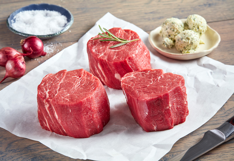 Well-trimmed filet mignon steaks with herb butter, shallots and seasoning