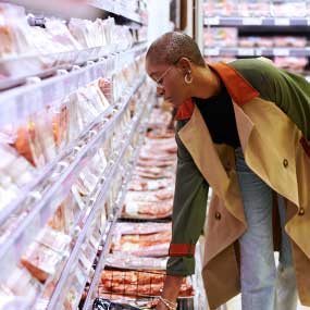 A woman shopping at the meat case